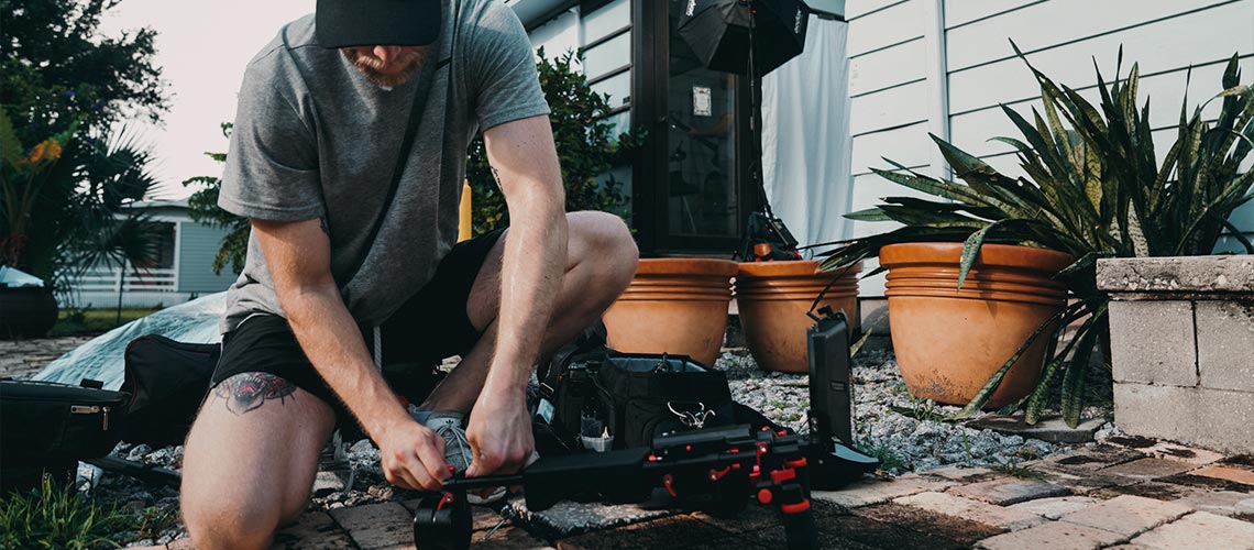 Man sets up a tripod 