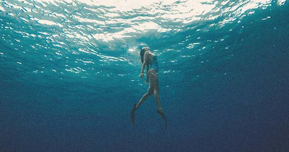 Girl swims to the surface of the water